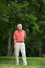 Senior man standing in park.