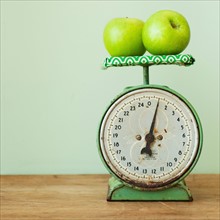 Apples on old-fashioned kitchen scale, studio shot.