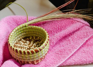 USA, South Carolina, Charleston, Close up of sweetgrass basket on towel.