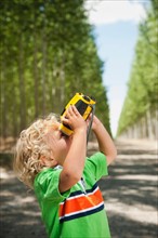 Boy (2-3) looking through binoculars.