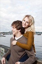 USA, Washington, Seattle, Young couple on pier, woman looking at camera. Photo: Take A Pix Media