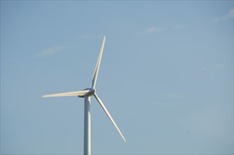Turkey, Izmir, wind turbine against blue sky. Photo : Tetra Images