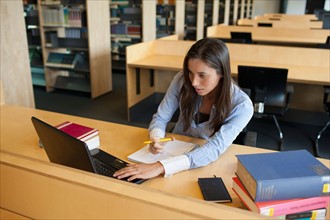 Female student studying in library. Photo : Jan Scherders