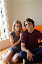 Portrait of young couple in living room. Photo : Rob Lewine