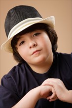 Studio portrait of boy (10-11) wearing hat. Photo: Rob Lewine