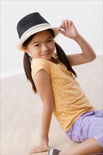 Studio portrait of girl (8-9) wearing hat. Photo : Rob Lewine