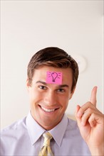 Portrait of businessman with adhesive note attached on forehead. Photo: Rob Lewine