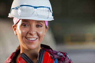 Portrait of female manual worker wearing hardhat. Photo : db2stock
