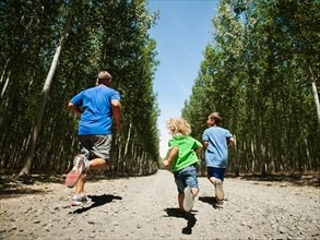 Father with sons (2-9) running up country road. Photo: Erik Isakson