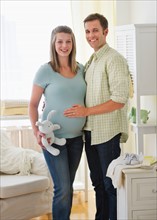 Young couple standing in nursery.
