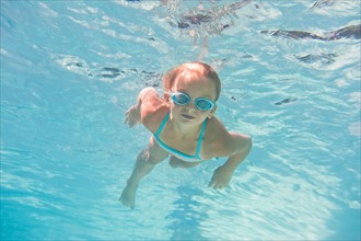 Girl (10-11) swimming underwater. Photo : Daniel Grill