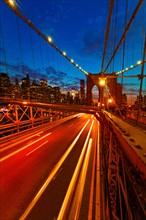 USA, New York City, Brooklyn Bridge with light trails at dusk.