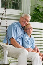Grandfather and grandson (10-11) sitting on porch swing.