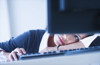 Businesswoman looking tired in front of computer.