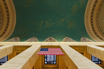 USA, New York City, Grand Central station interior with US flag.