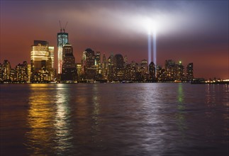 USA, New York City, Manhattan skyline with 9/11 memorial lights.