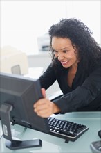 Business woman shaking computer monitor.