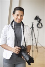 Portrait of woman with digital camera.