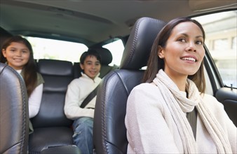 Mother with son (12-13) and daughter (10-11) in car .