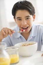 Boy (12-13) having cereals for breakfast.