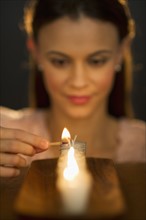 Woman igniting candle.
