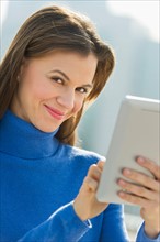 Woman using digital tablet outdoors.