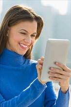 Woman using digital tablet outdoors.