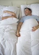 Couple in bed, man snoring.