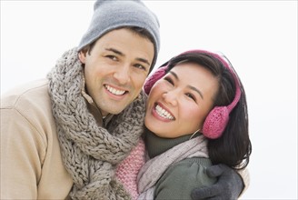 Couple wearing warm clothing smiling.