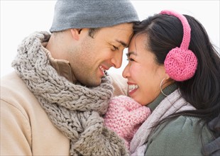 Couple wearing warm clothing looking at each other.