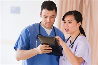 Portrait of doctor and nurse using digital tablet.