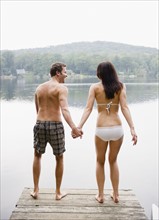 USA, New York, Putnam Valley, Roaring Brook Lake, Couple standing on pier by lake. Photo: Jamie