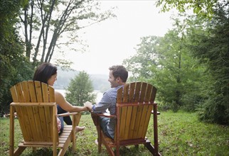 USA, New York, Putnam Valley, Roaring Brook Lake, Couple relaxing by lake. Photo: Jamie Grill