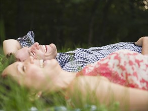 Roaring Brook Lake, Couple lying on grass. Photo : Jamie Grill