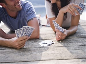 Roaring Brook Lake, Couple playing cards on pier. Photo : Jamie Grill