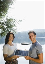 Roaring Brook Lake, Couple holding solar panel. Photo : Jamie Grill