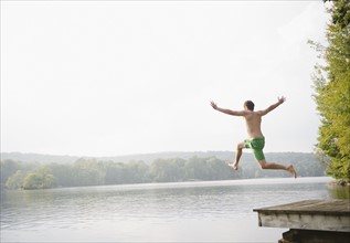 Roaring Brook Lake, Man jumping from pier to lake. Photo: Jamie Grill