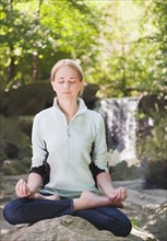 USA, New York, New York City, Manhattan, Central Park, Young woman practicing yoga. Photo : Daniel