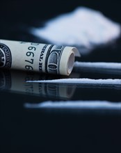 Close up of cocaine and rolled up banknote on black background. Photo : Daniel Grill