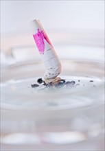 Close up of cigarette butt with mark of pink lipstick. Photo : Daniel Grill