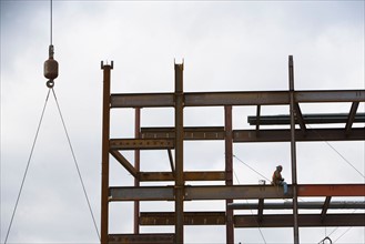 USA, New York City, Construction worker sitting on unfinished structure. Photo: fotog