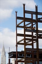 USA, New York City, Construction worker sitting on unfinished structure. Photo: fotog