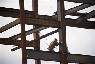 Construction worker working on unfinished structure. Photo : fotog