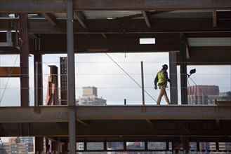 USA, New York City, Construction worker walking inside of unfinished structure. Photo : fotog