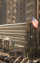 USA, New York City, Street scene with american flag flying outside office building. Photo : fotog
