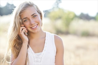 Teenage girl (16-17) using mobile phone outdoors. Photo : Take A Pix Media