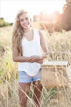 Outdoors portrait of teenage (16-17) with picnic basket . Photo: Take A Pix Media
