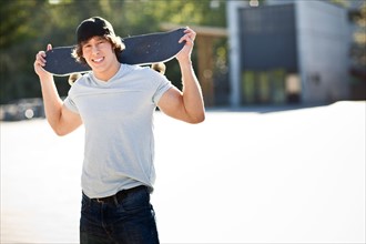 young man posing with skateboard. Photo: Take A Pix Media