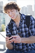 USA, Washington, Seattle, Man text messaging outdoors. Photo : Take A Pix Media