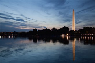 USA, Washington DC, Washington Monument reflecting in water at dusk. Photo : Johannes Kroemer